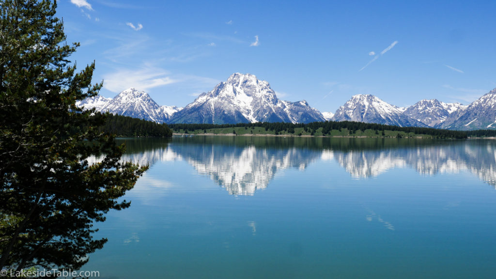 Clear water reflecting snow capped mountains. Glorious! | www.lakesidetable.com