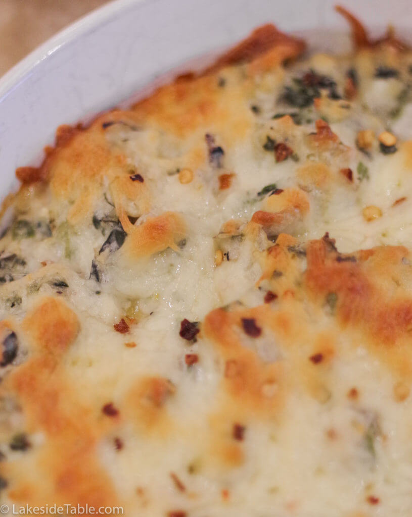 spinach artichoke dip out of the oven with a golden brown cheesy top