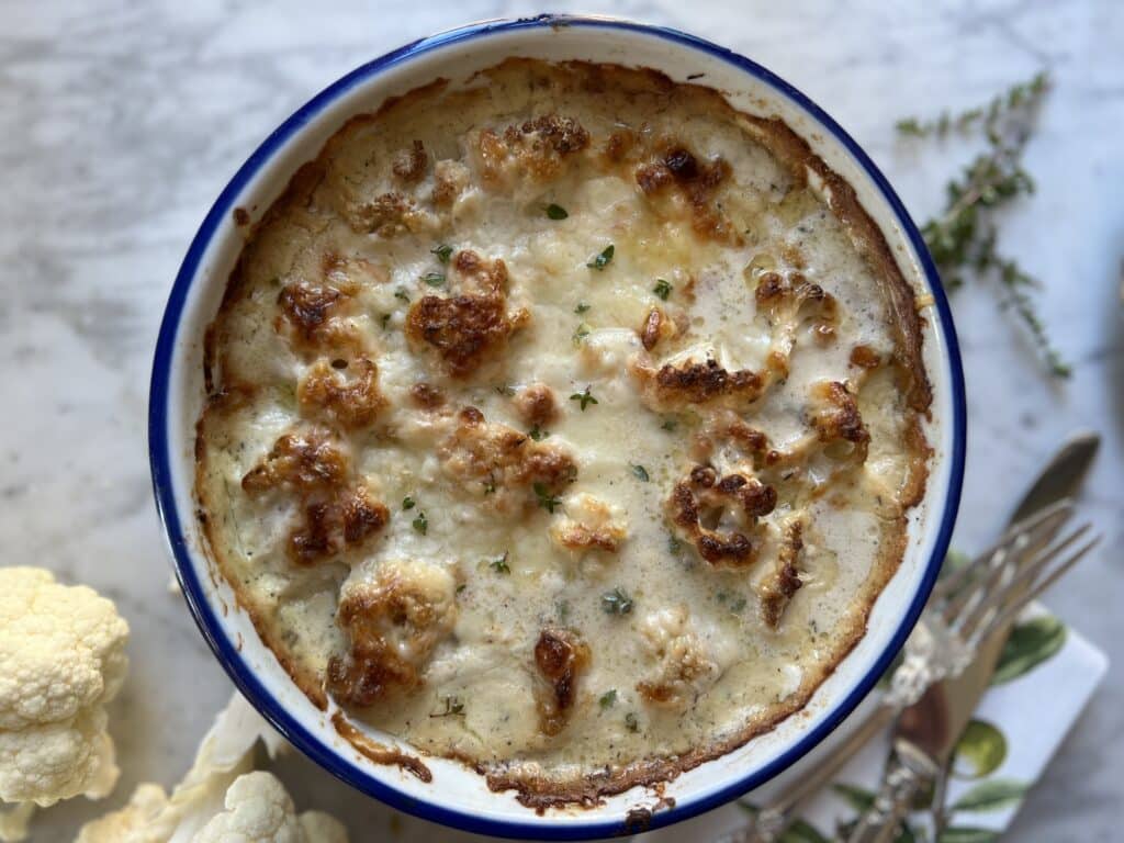 cauliflower gratin recipe in white and blue round baking dish