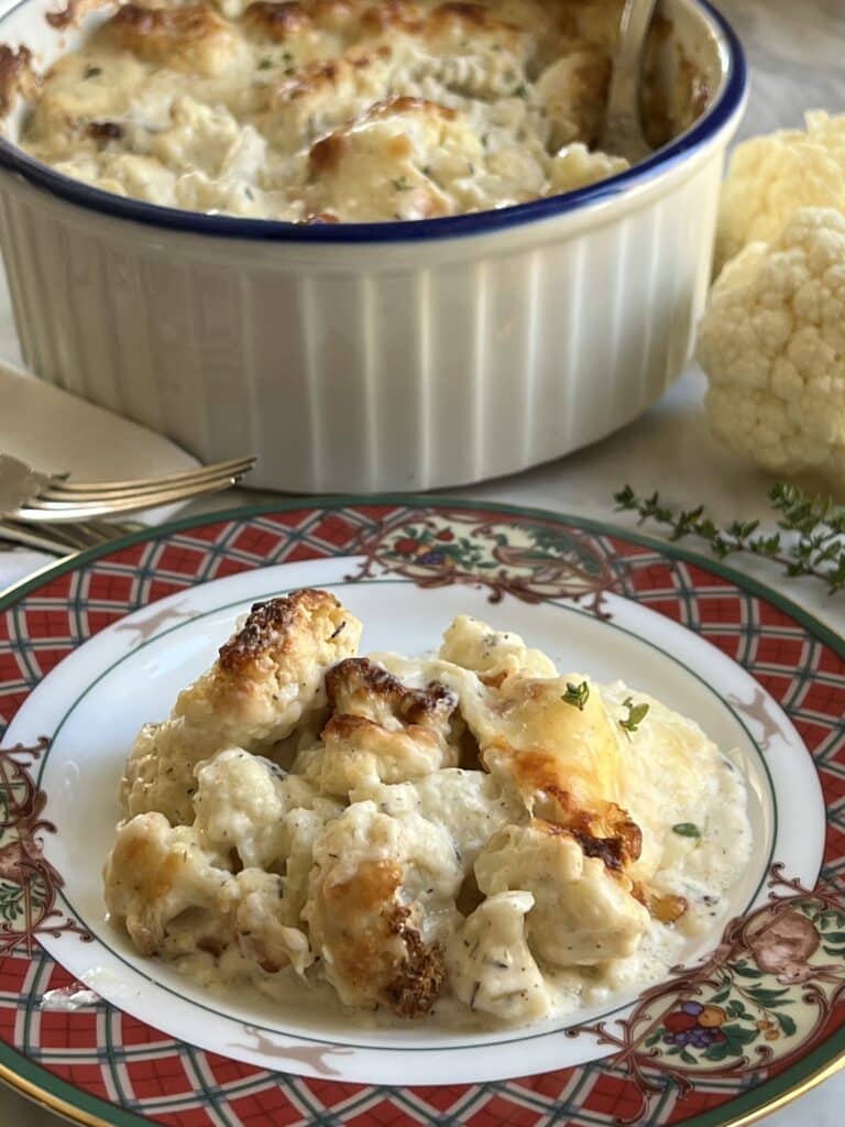 plate of cauliflower gratin with baking dish behind it