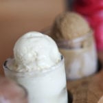 5 ice creams lined up in separate cups on a board on a wooden table