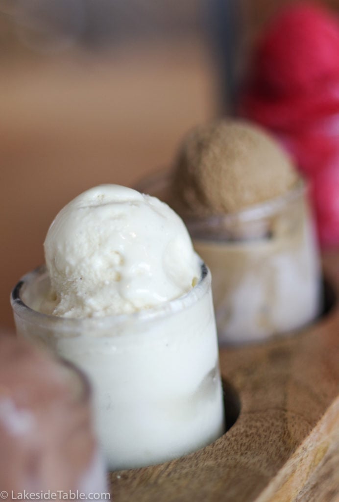 5 ice cream flavors lined up in separate cups on a board on a wooden table