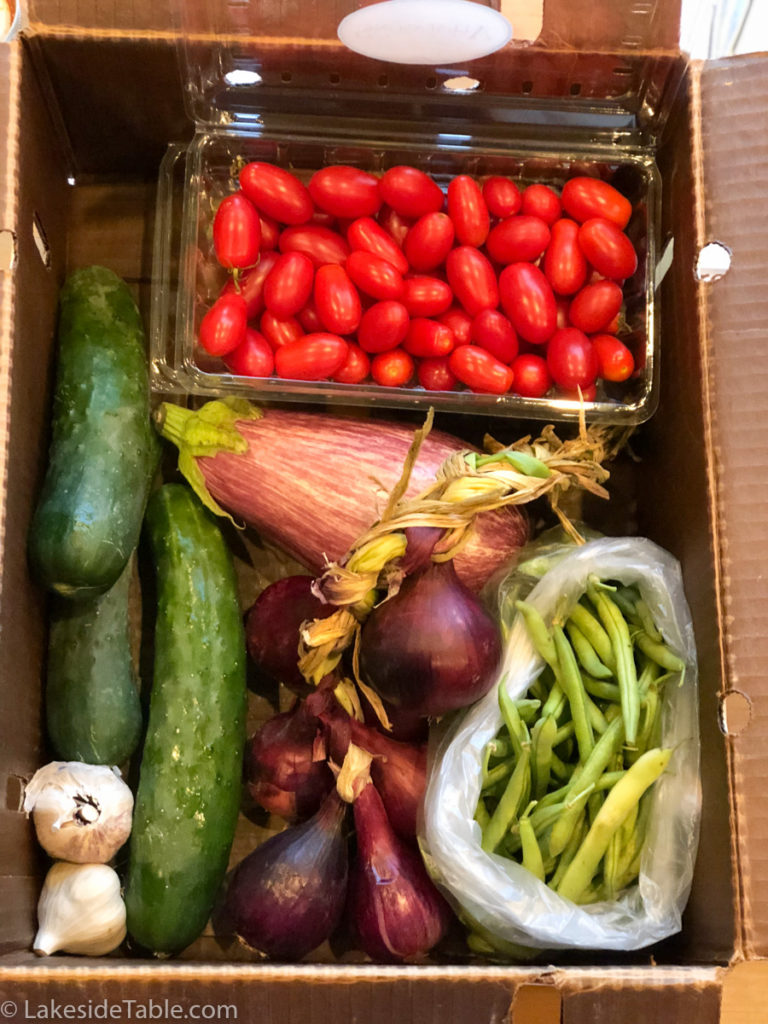  LEAF Little Egypt Alliance of Farmers Box full of organic produce: cherry tomatoes, cucumbers, eggplant, garlic, beans and onions