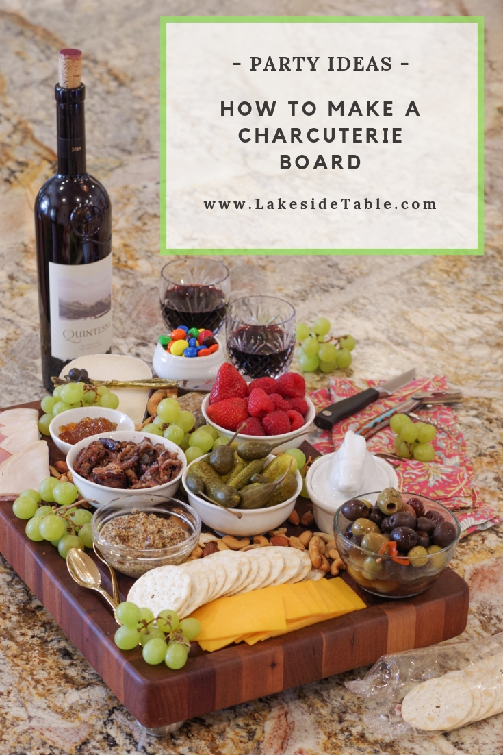 A cutting board loaded down with tons of meats, cheese, fruit and nuts
