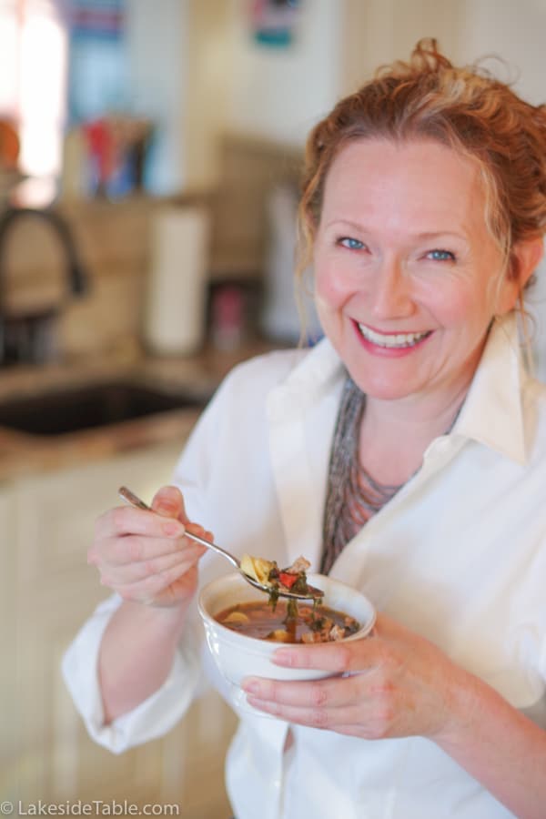 Madalaine holding a bowl of easy tortellini soup in her kitchen