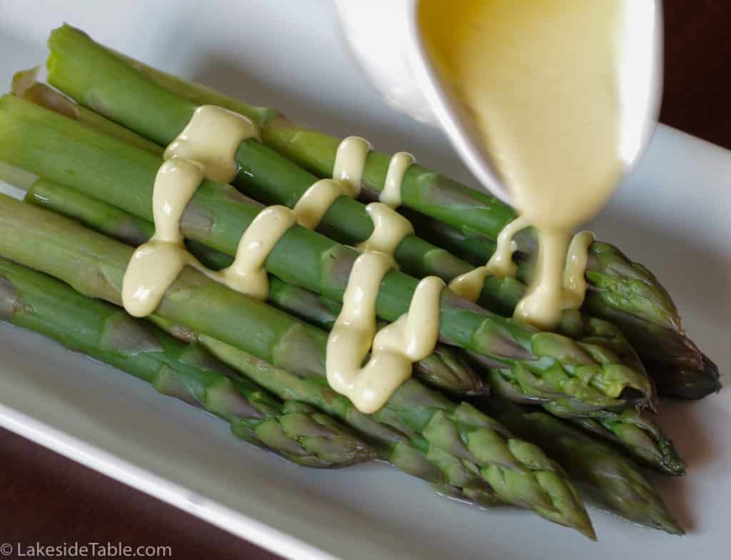 smooth hollandaise sauce over steamed asparagus