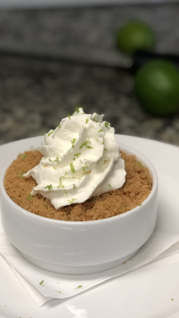 key lime pie with crust on top with whip cream and green lime zest