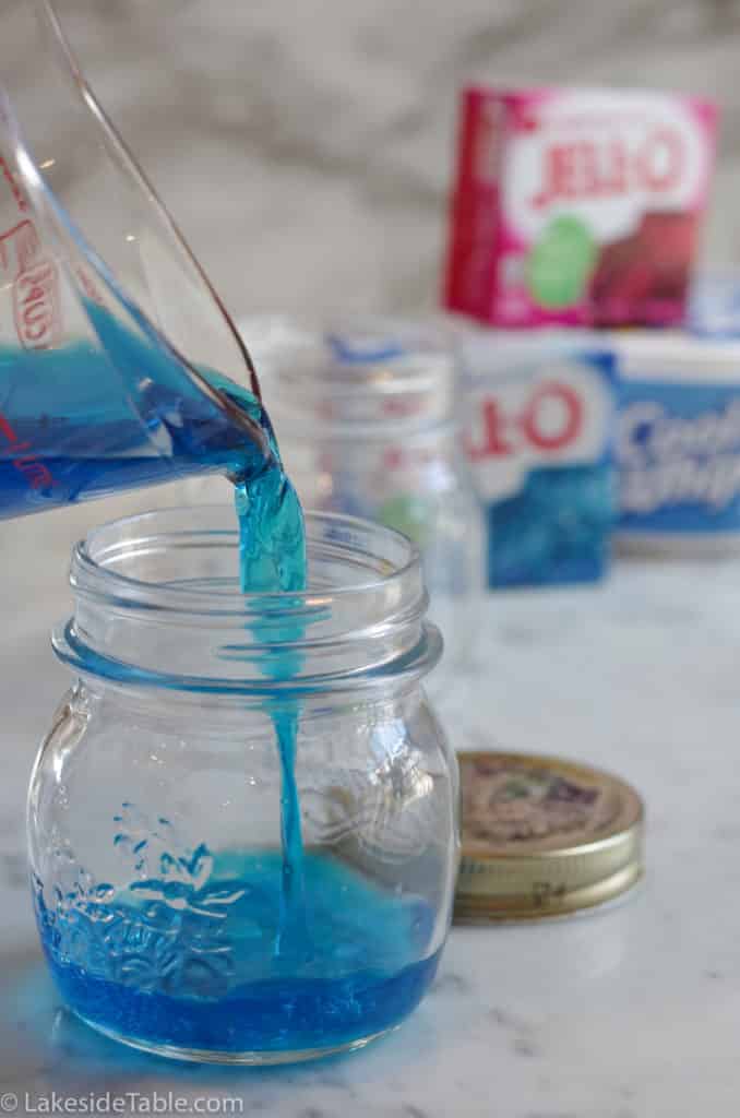 pouring blue jello into small mason jar