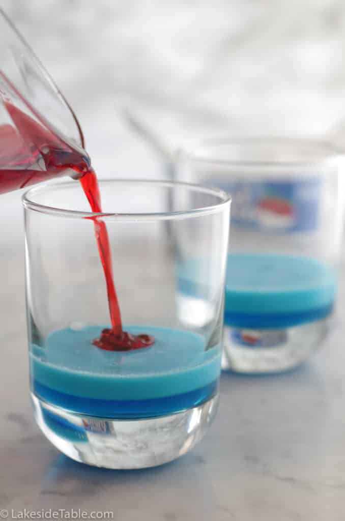 pouring red jello over creamy blue layer