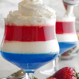 putting redi whip on top of red white and blue fourth of july jello dessert
