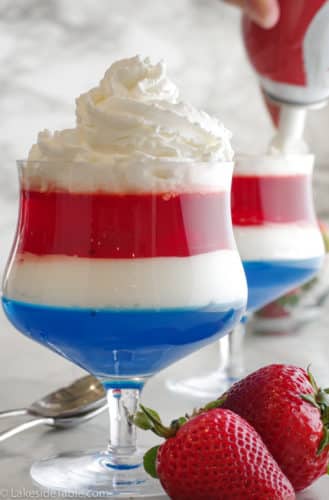 putting redi whip on top of red white and blue fourth of july jello dessert