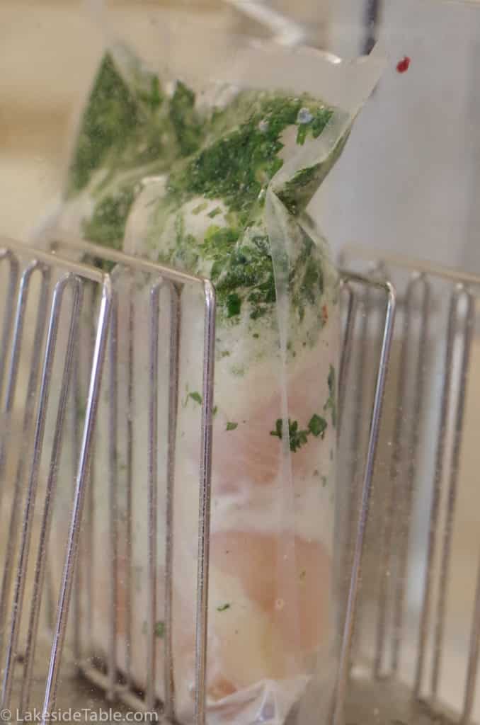 cooking chicken sous vide with chimichurri sauce in bag with the chicken