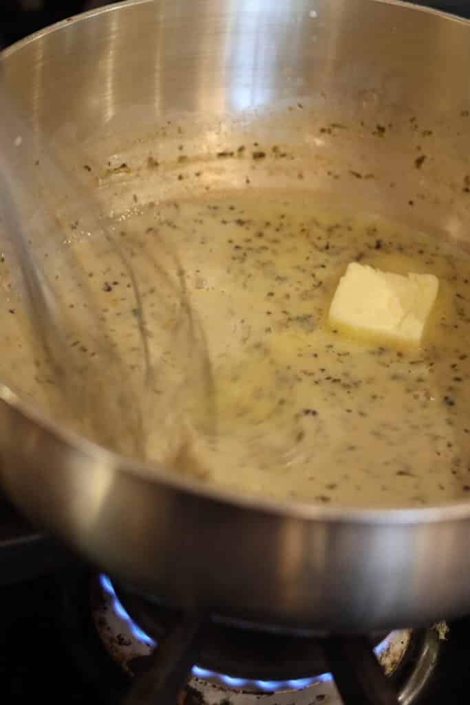 whisking butter into cheese sauce