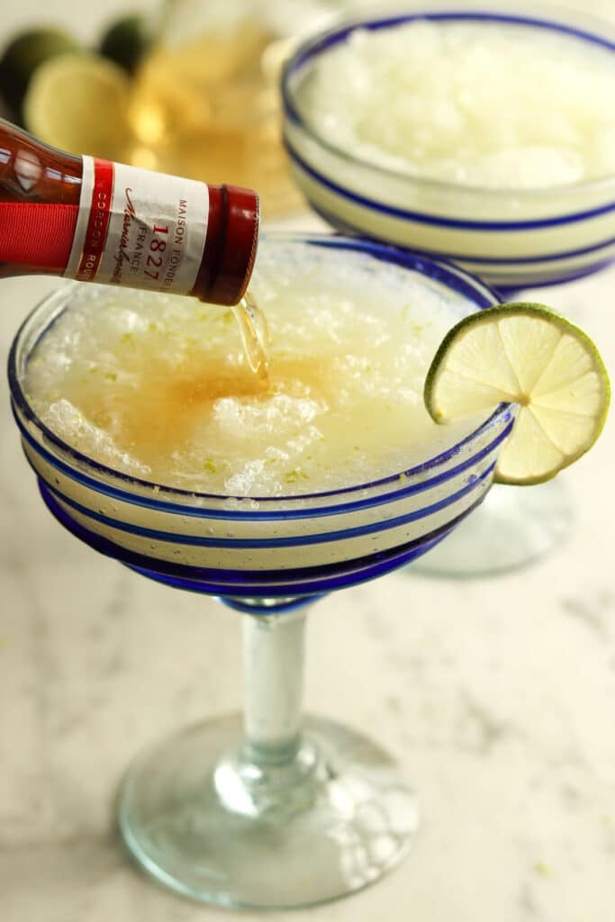 pouring grand marnier into a frozen margarita