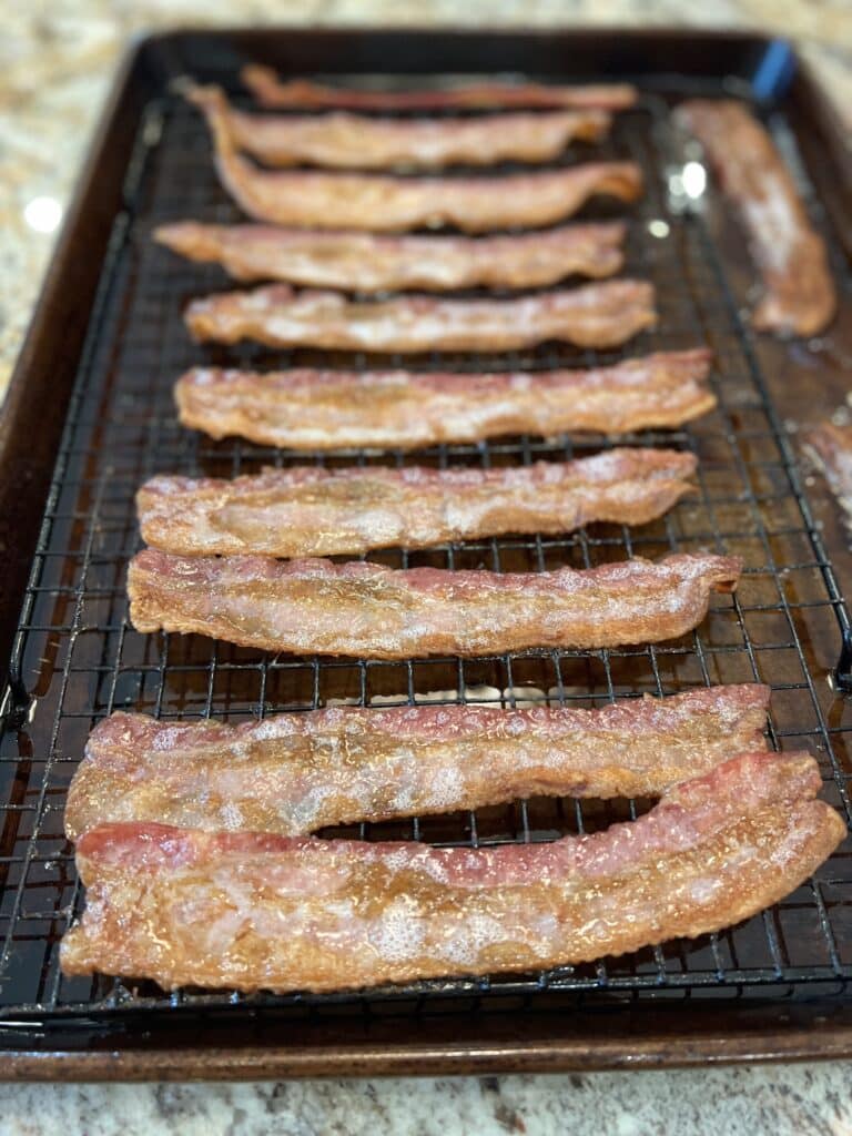 baked bacon on cooling rack and baking sheet