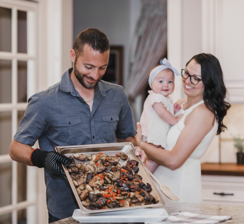 man, woman, and baby in kitchen smiling