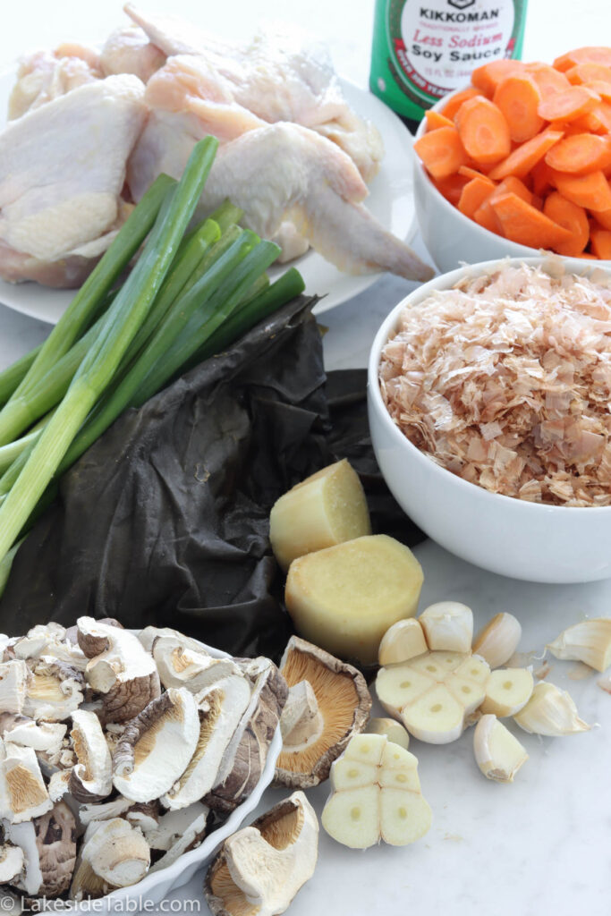 ramen broth ingredients: soy sauce, chicken wings, bonito, kelp, scallions, dried shiitake mushrooms, garlic, carrots, and ginger