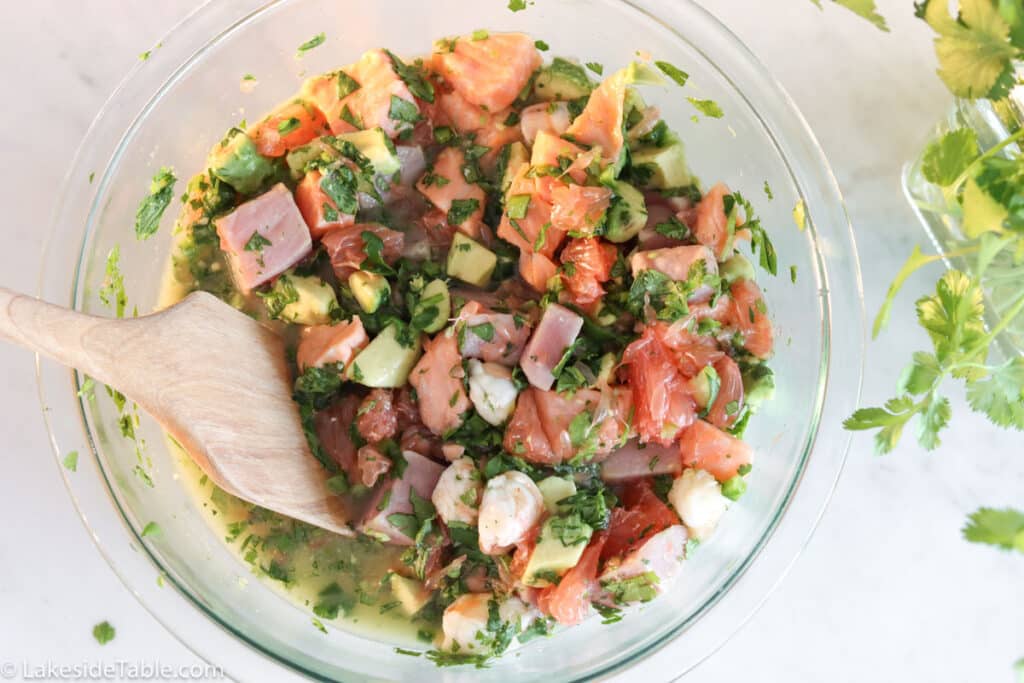 top down view of a glass bowl filled with marinating ceviche