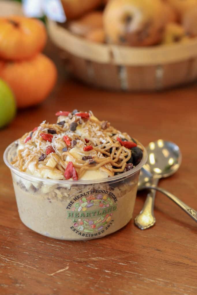 Pumpkin and acai bowl topped with granola, goji, coconut, bananas, and nut butter drizzle.