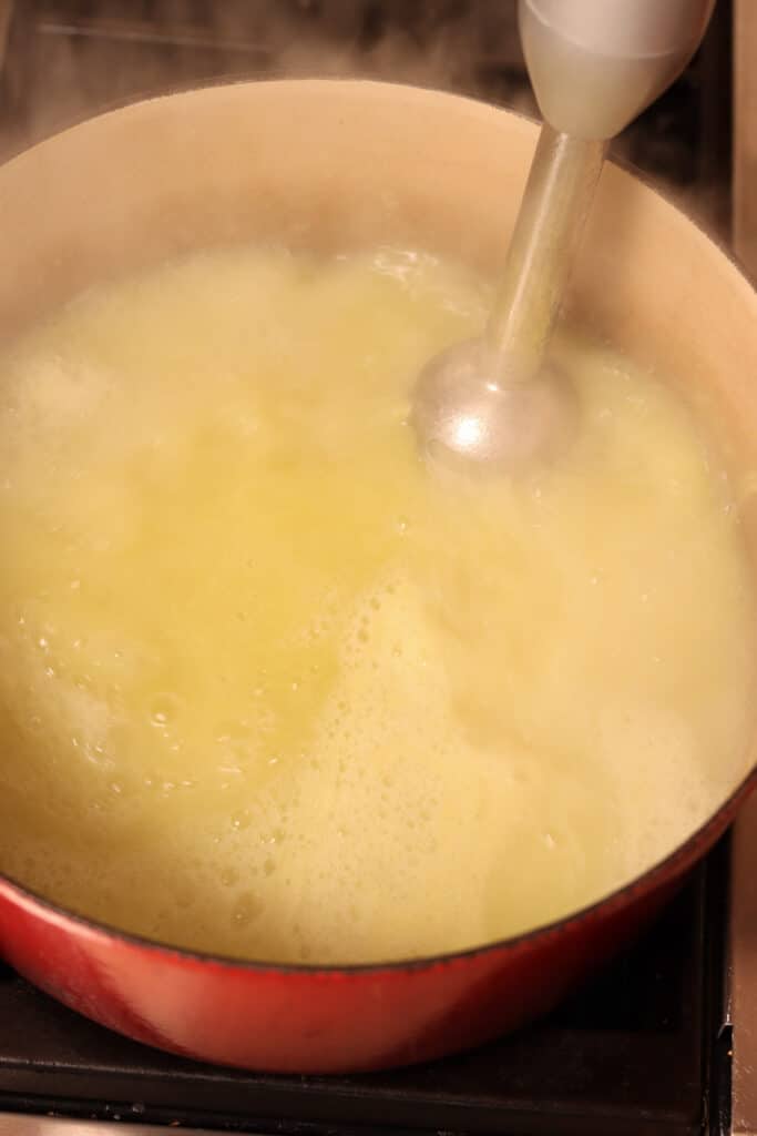 using an immersion blender to smooth soup