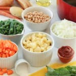 Ingredients for Soupe au Pistou laid out: potatoes, navy beans, green beans, carrots, onions, tomato paste, pasta, salt, fresh basil, garlic, and saffron