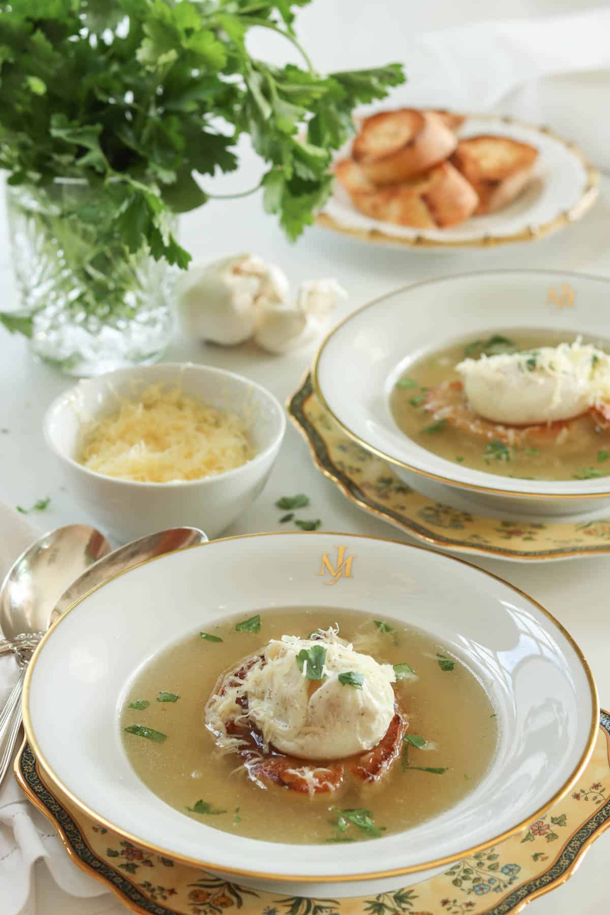 clear garlic soup with poached egg and toasted bread topped with green fresh parsley flakes