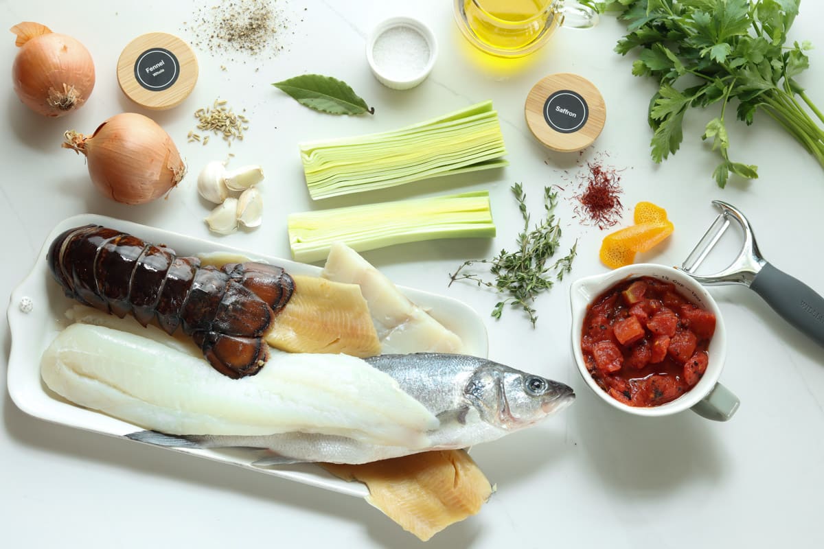 ingredients for bouillabaisse: fish, shellfish, leeks, onion, garlic, fennel seeds, salt, pepper, bay leaf, orange rind, tomatoes, thyme, olive oil, parsley